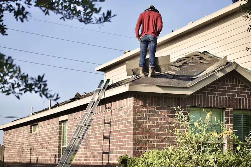 Professional roofer working on a residential roof in Far Rockaway